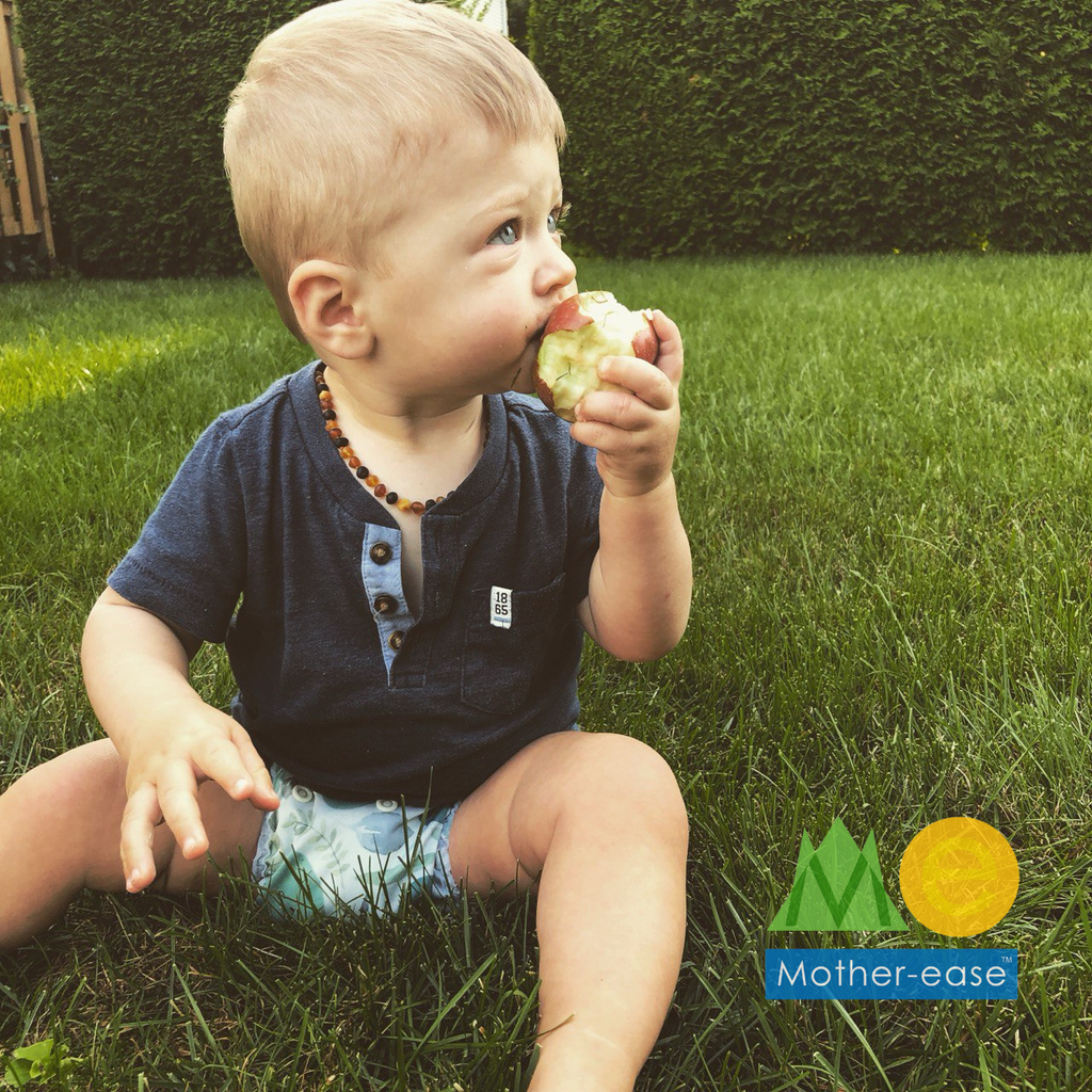 baby wearing ME diaper eating an apple